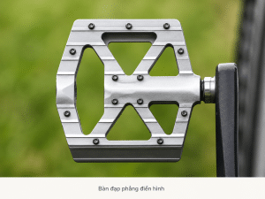 Bàn đạp phẳng xe đạp với bề mặt rộng, nhiều chốt bám và thiết kế kim loại chắc chắn, phù hợp cho người mới đạp xe, xe địa hình, xe đi lại hằng ngày và các nhu cầu ưu tiên sự an toàn, dễ sử dụng.